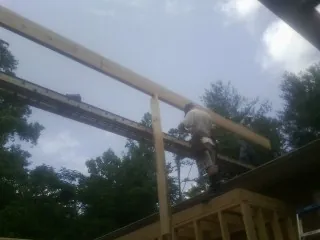 Carpenter setting a ridge beam over a new addition frame — Ice Dam Removal by Roofing Brothers in Smicksburg
