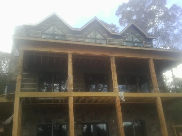 Dormers and porch framing on a large log home under construction — Roof Coating work by our crew in Smicksburg