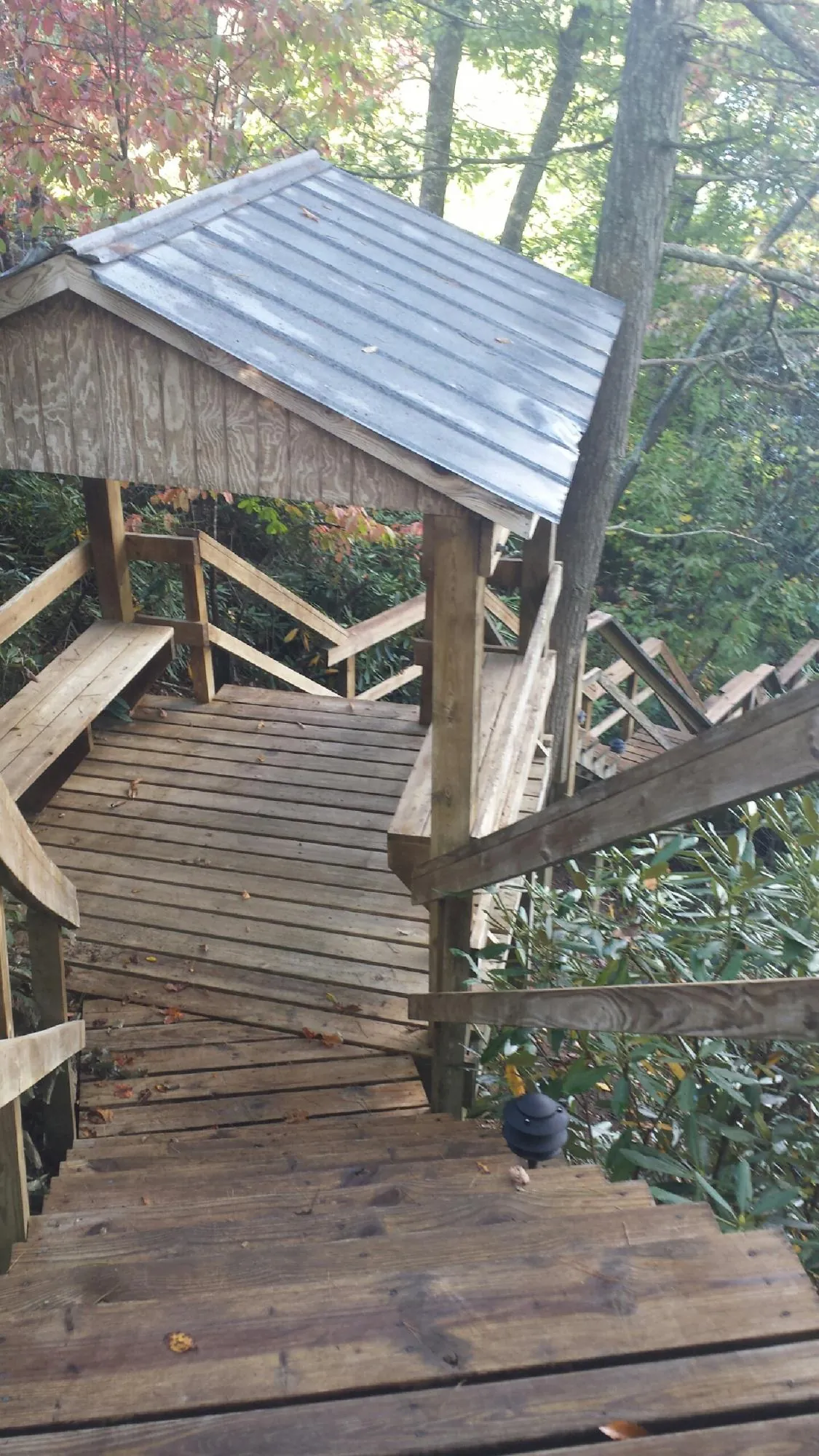 Metal roofed shelter over wooden steps on a wooded walkway — Skylight Repair & Installation work by our crew in Smicksburg