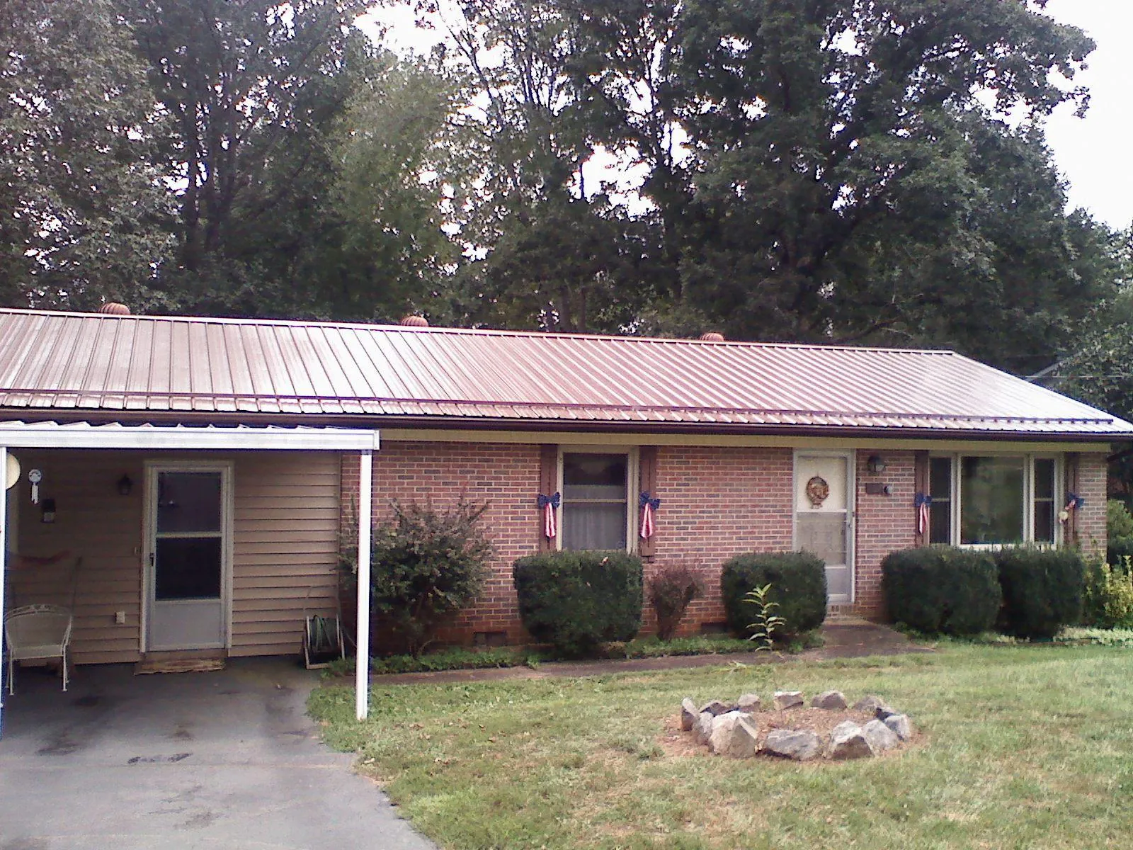 Bronze metal roof and carport on a brick ranch home — Roof Repair work by our crew in Smicksburg